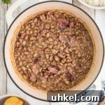 Overhead shot of a pot of pinto beans, cropped square.