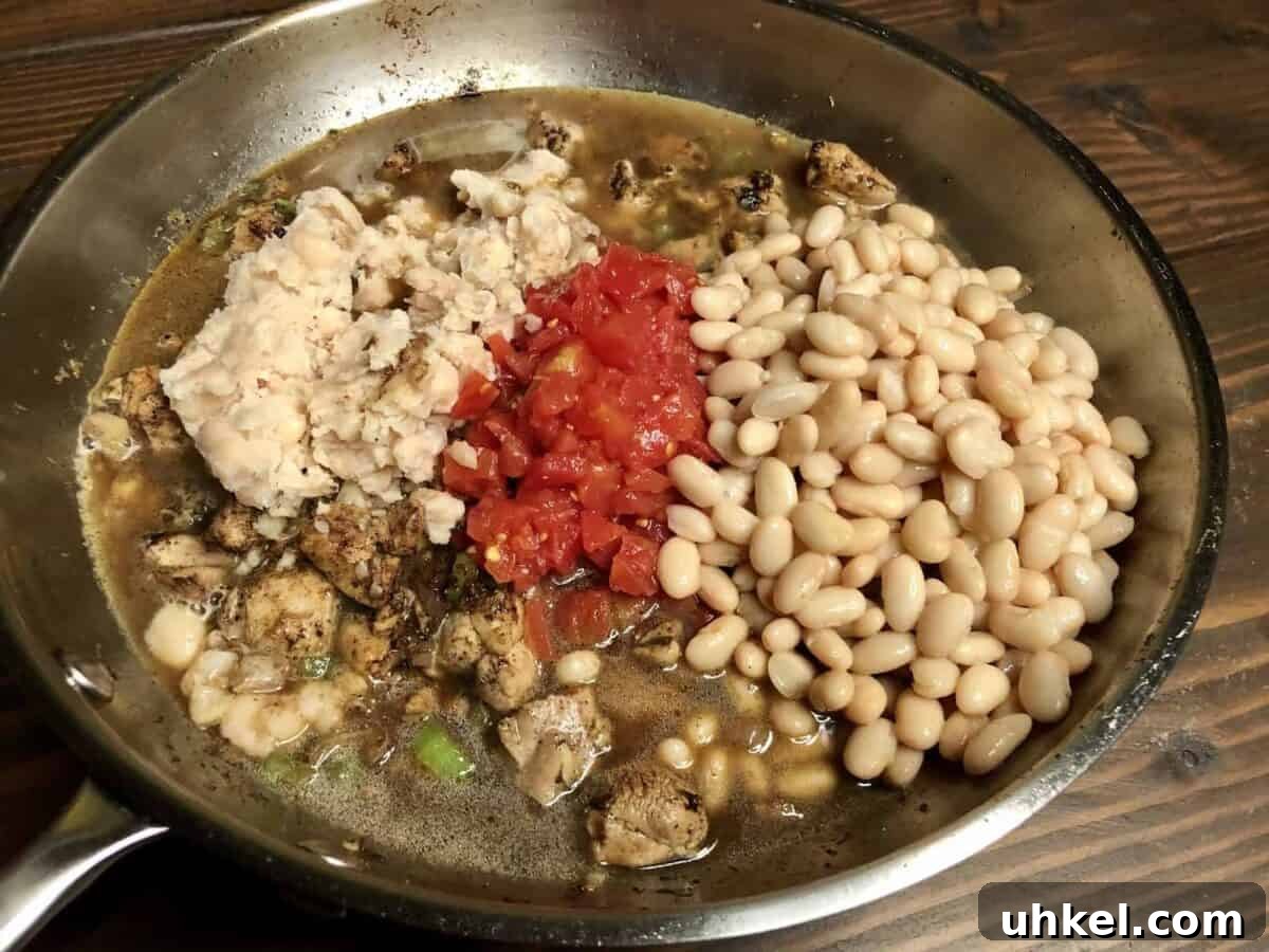 Creamy One-Pan Chicken with Beans and Garlic Herb Sauce 6 Add mashed and whole beans, tomatoes, and stock.