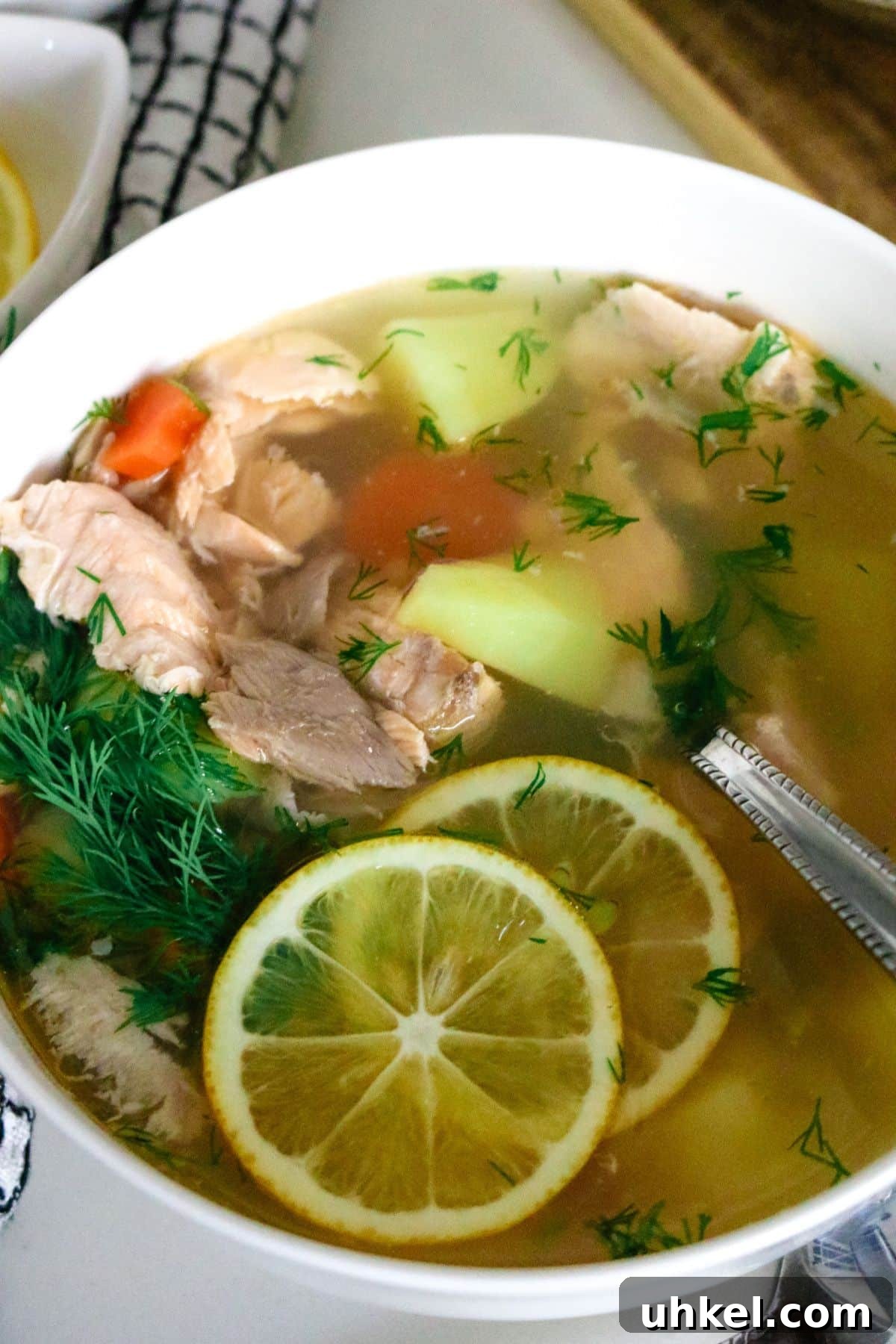 Authentic Ukha Fish Soup Recipe: Clear Russian Fisherman’s Broth 12 spoon inside a white bowl of fish soup