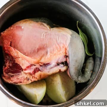 beef tongue with onions and bay leaves in instant pot inner pot.