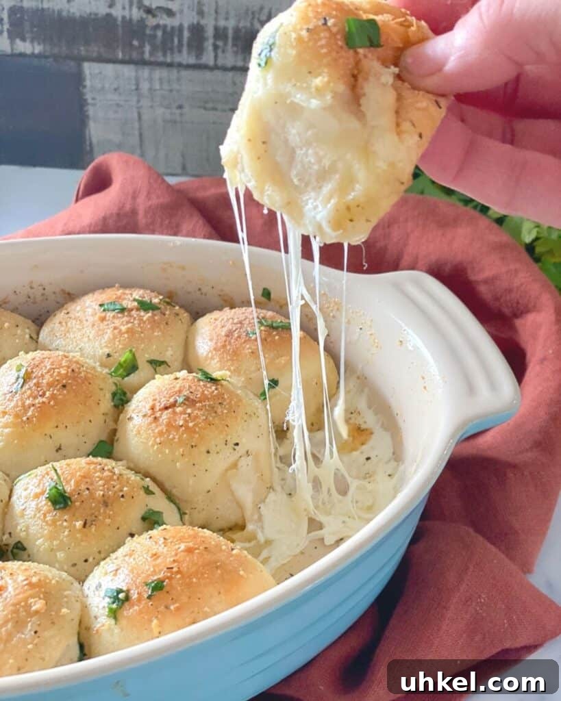 97 Crowd-Pleasing Appetizer Ideas for Parties and Gatherings 11 cheesy stuffed biscuit bombs appetizer being pulled from dish.