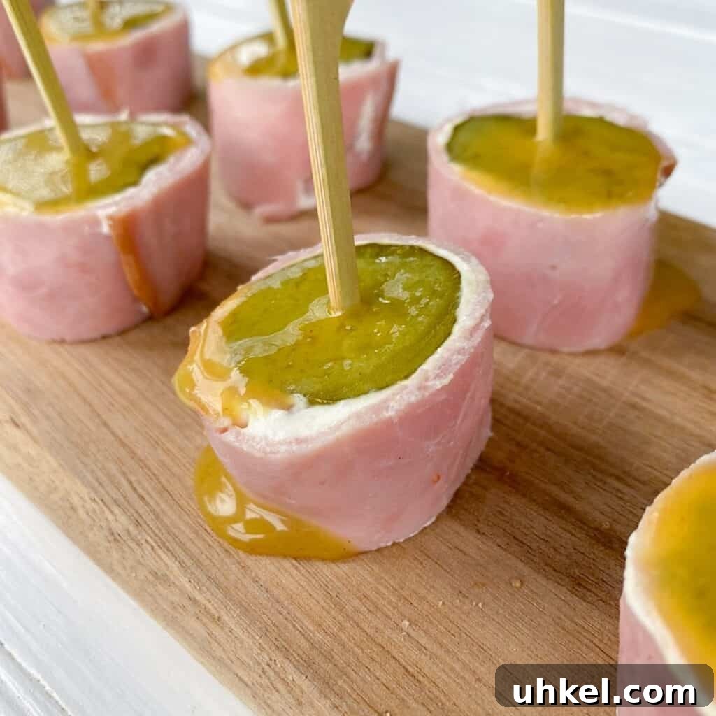 97 Crowd-Pleasing Appetizer Ideas for Parties and Gatherings 6 ham pickle and cream cheese appetizer on wooden cutting board skewered