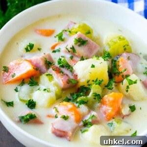 A bowl of ham and potato soup loaded with veggies in a creamy broth.