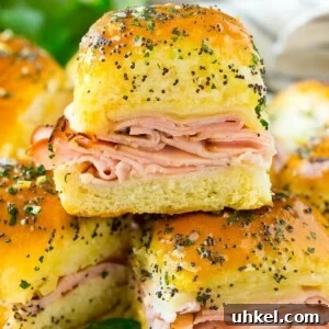 Ham and cheese sliders on a serving plate, garnished with parsley.