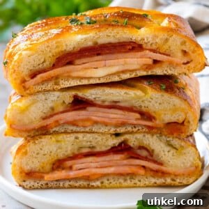 A stromboli recipe with pepperoni, ham and cheese wrapped up in pizza dough and baked.
