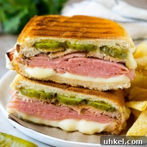 A pressed Cuban sandwich with layers of ham, cheese and pickles.