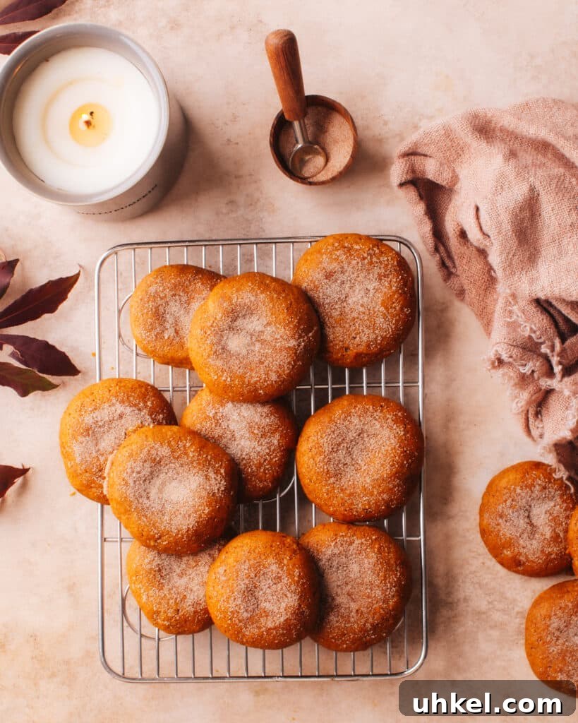 Pumpkin Cookies on a counter with a candle and fall leaves.