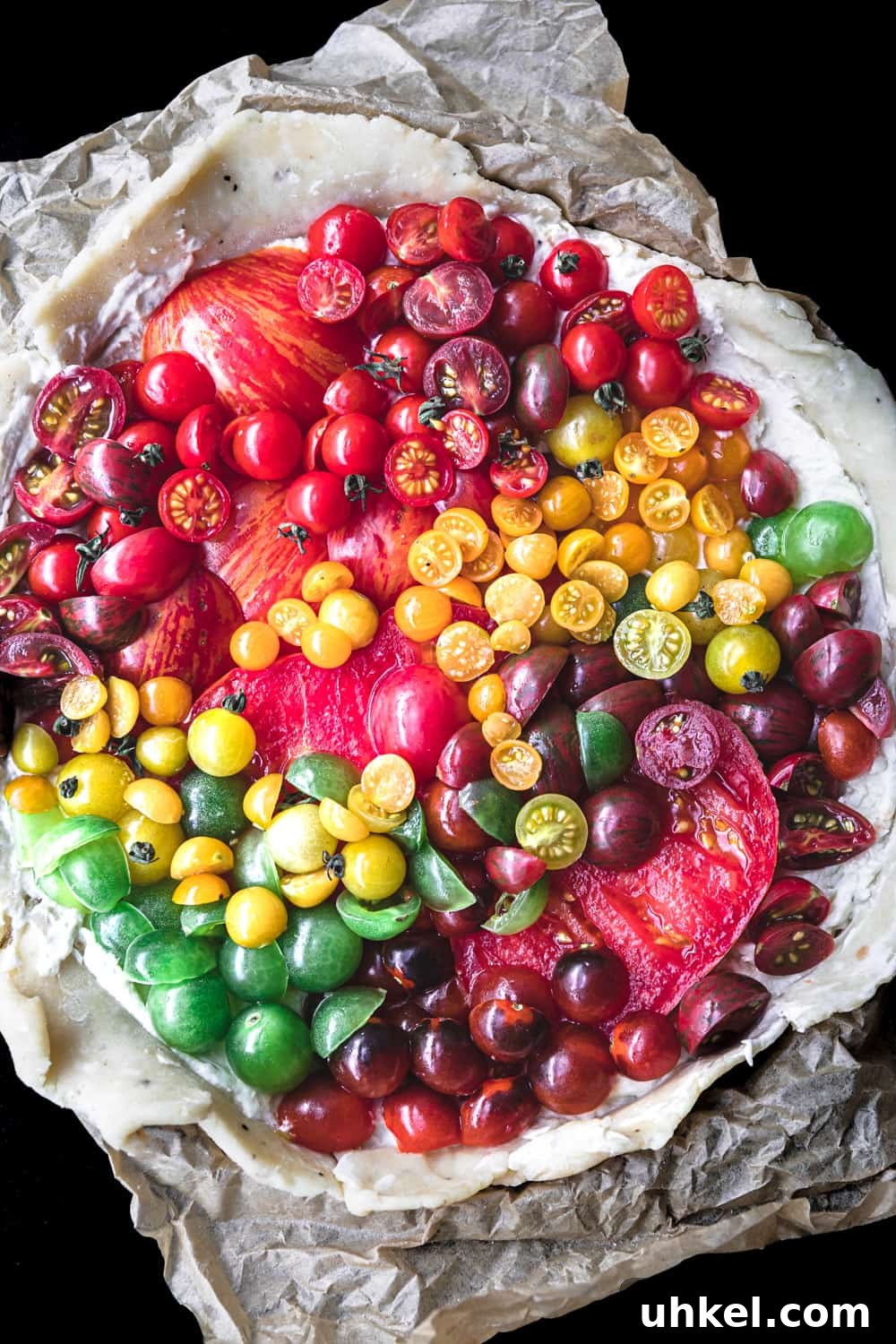 Ultimate Tomato Galette Recipe You’ll Make Again and Again 2 a raw and round tomato galette with red, orange, yellow and green tomatoes