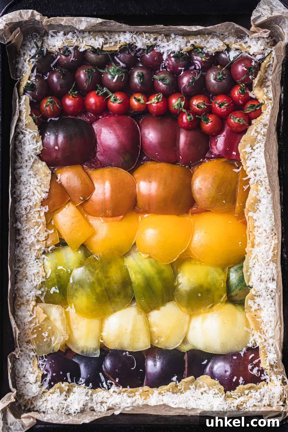 Ultimate Tomato Galette Recipe You’ll Make Again and Again 4 a raw tomato galette, with colorful red, orange, yellow, green and purple tomatoes arranged like a rainbow.