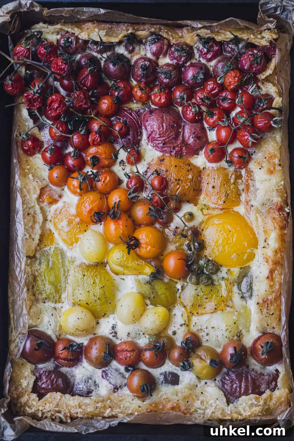Ultimate Tomato Galette Recipe You’ll Make Again and Again 6 Tomato galette just out of the oven, in a pan with parchment paper; overhead shot.