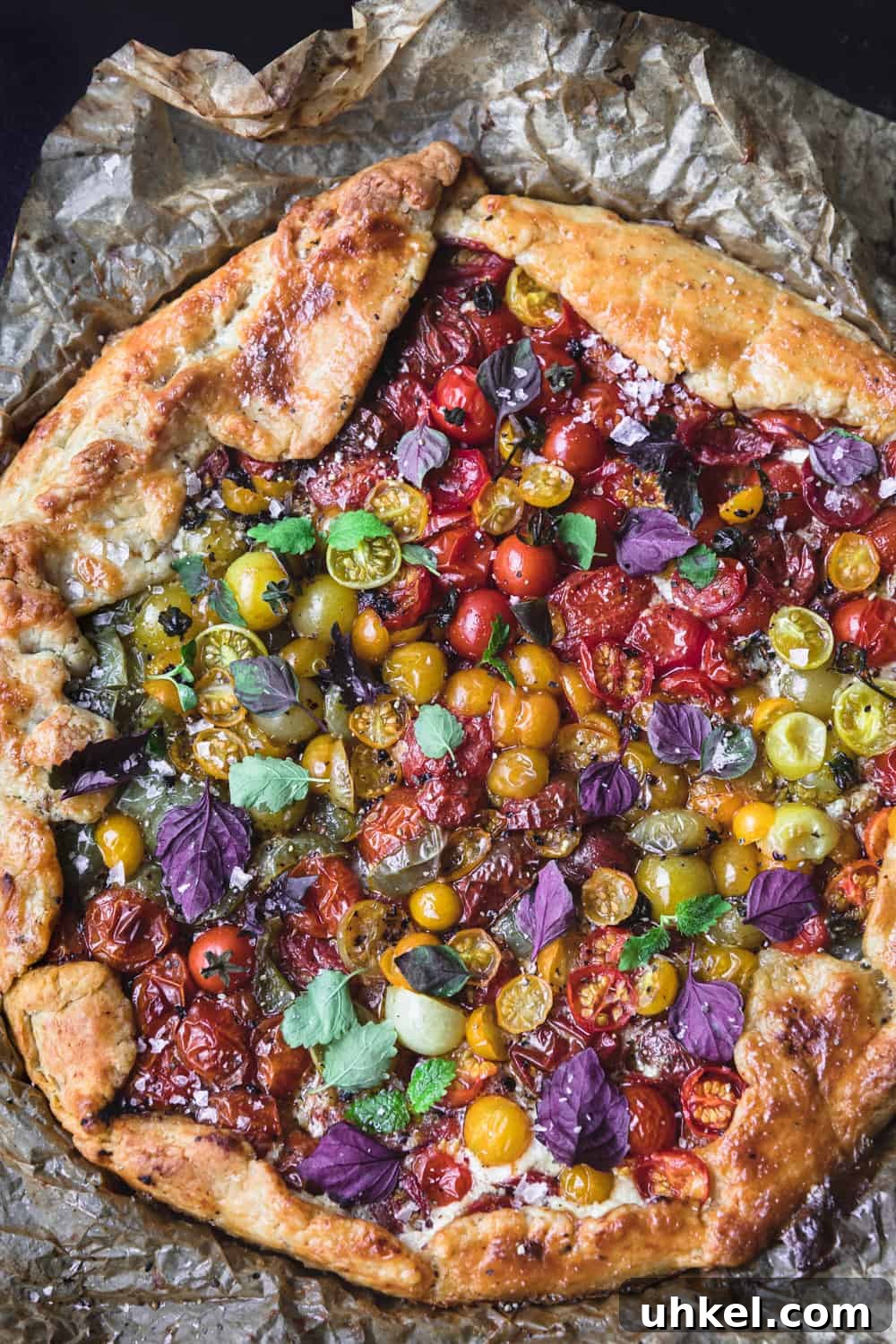Ultimate Tomato Galette Recipe You’ll Make Again and Again 9 baked tomato galette topped with basil on parchment paper