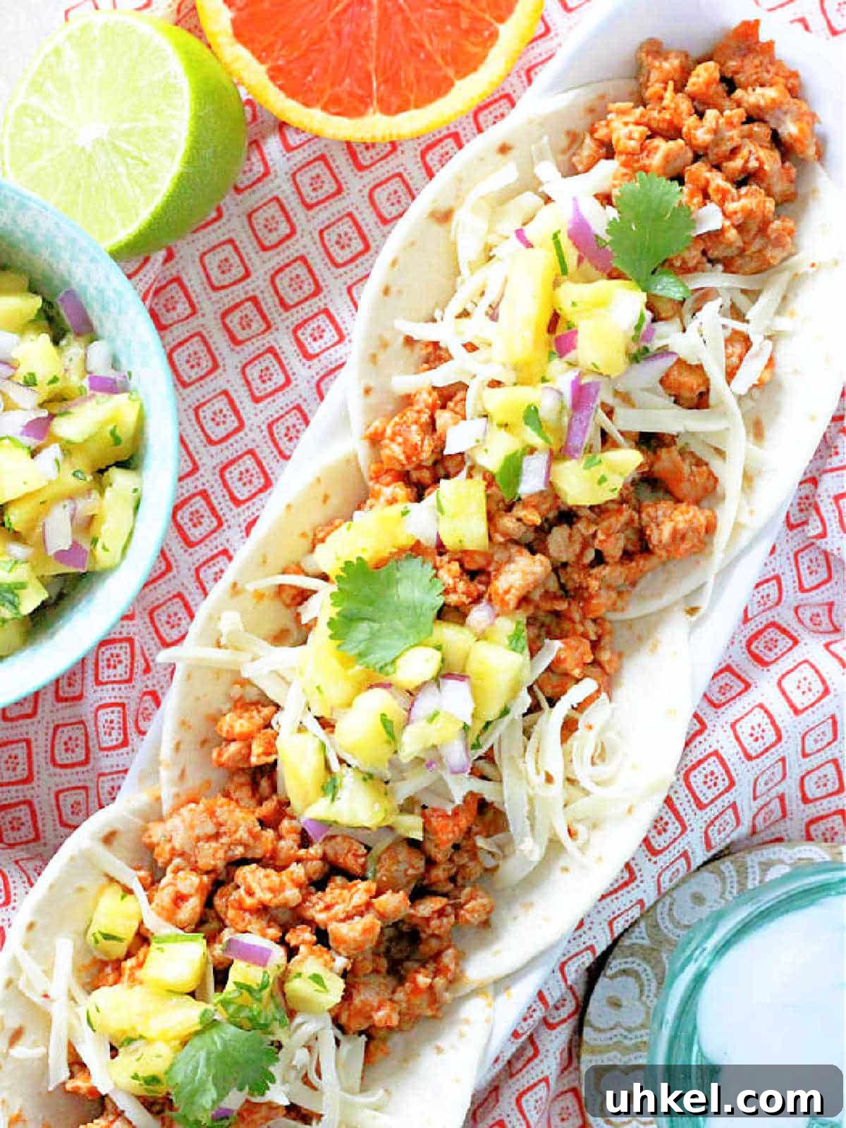 Juicy Ground Pork Tacos with Tangy Pineapple Salsa 2 three plated ground pork tacos topped with fresh pineapple salsa