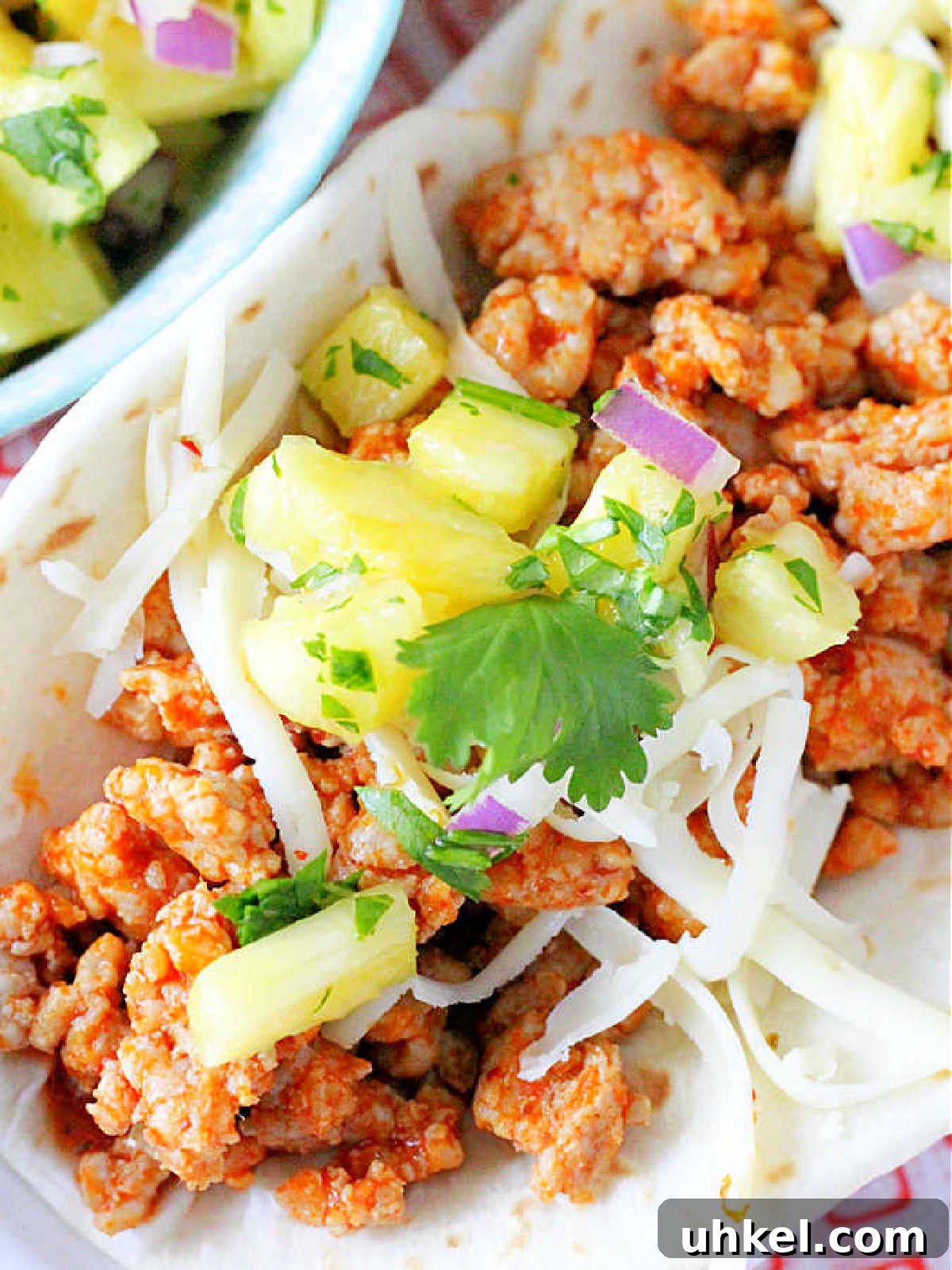 Juicy Ground Pork Tacos with Tangy Pineapple Salsa 3 close up of the ground pork taco meat inside of a flour tortilla