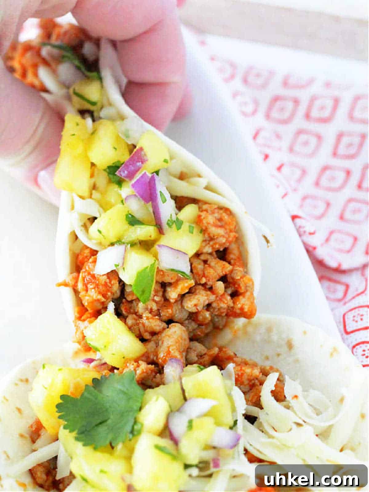 Juicy Ground Pork Tacos with Tangy Pineapple Salsa 4 holding a folded ground pork taco in my hand