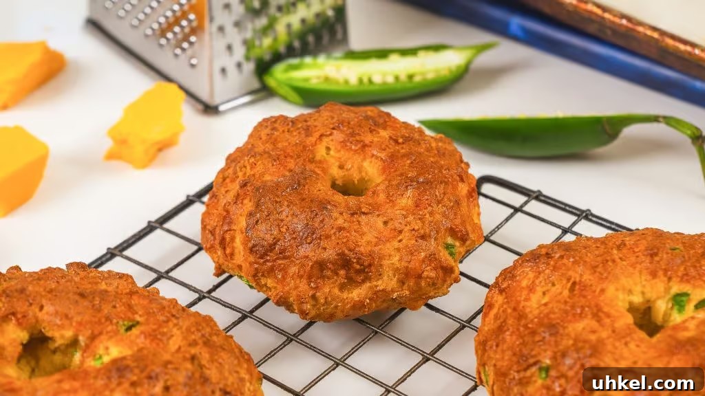 Homemade Jalapeno Cheddar Protein Bagel Recipe 3 close up image of crispy greek yogurt protein bagel with half a jalapeno in the back ground