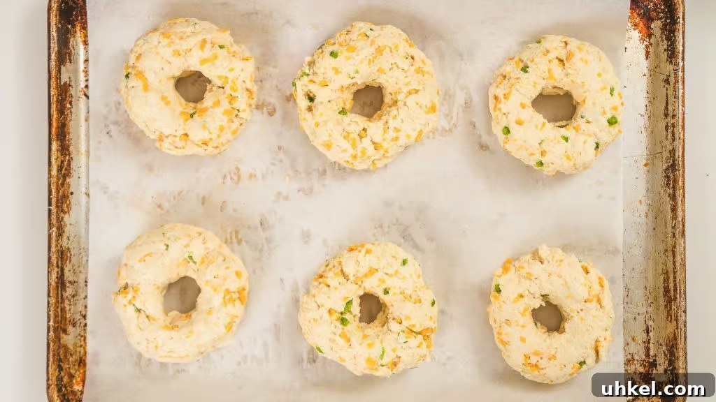 Homemade Jalapeno Cheddar Protein Bagel Recipe 4 overhead image of greek yogurt bagels recipe prior to being cooked. The bagels are on a sheet tray lined with parchment paper
