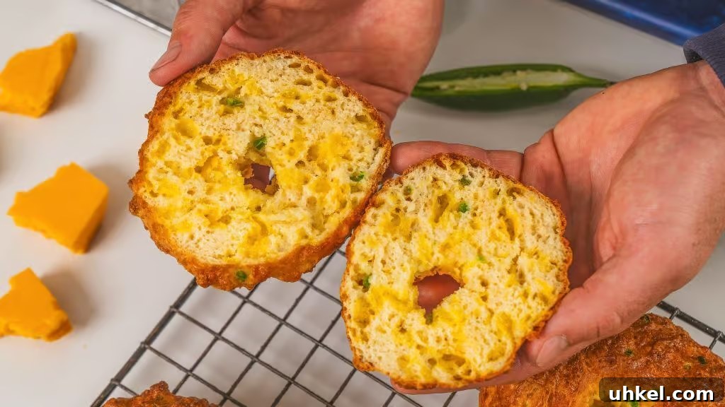 Homemade Jalapeno Cheddar Protein Bagel Recipe 8 two hands holding a bagel that has been sliced in two
