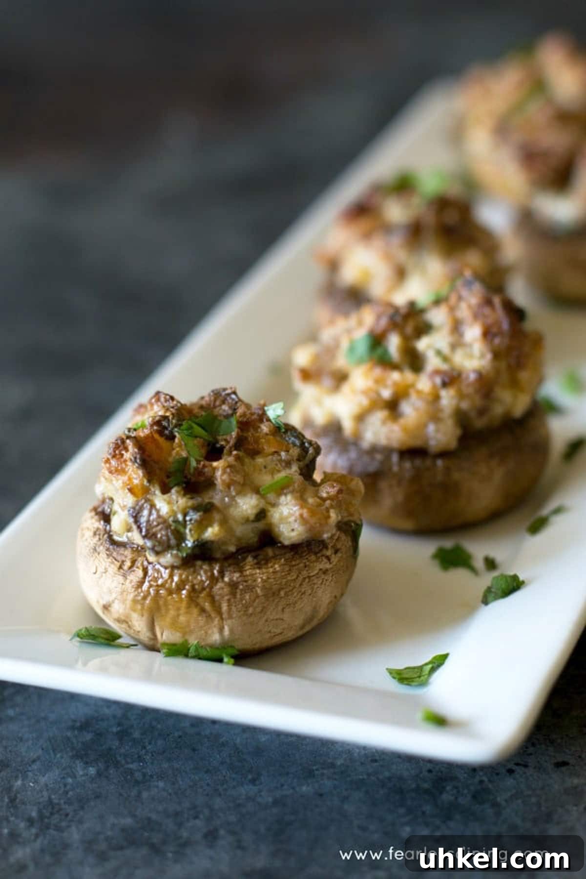 Gluten-Free Stuffed Mushrooms with Savory Herb Filling 2 A serving dish with stuffed mushrooms lined up.