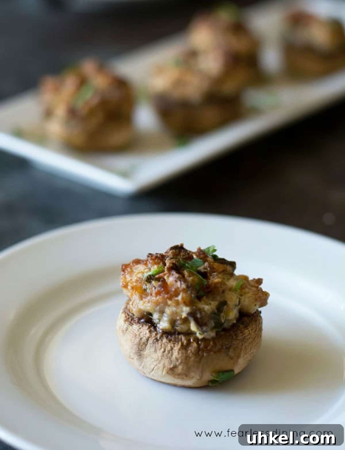 Gluten-Free Stuffed Mushrooms with Savory Herb Filling 5 A stuffed mushroom on a plate.