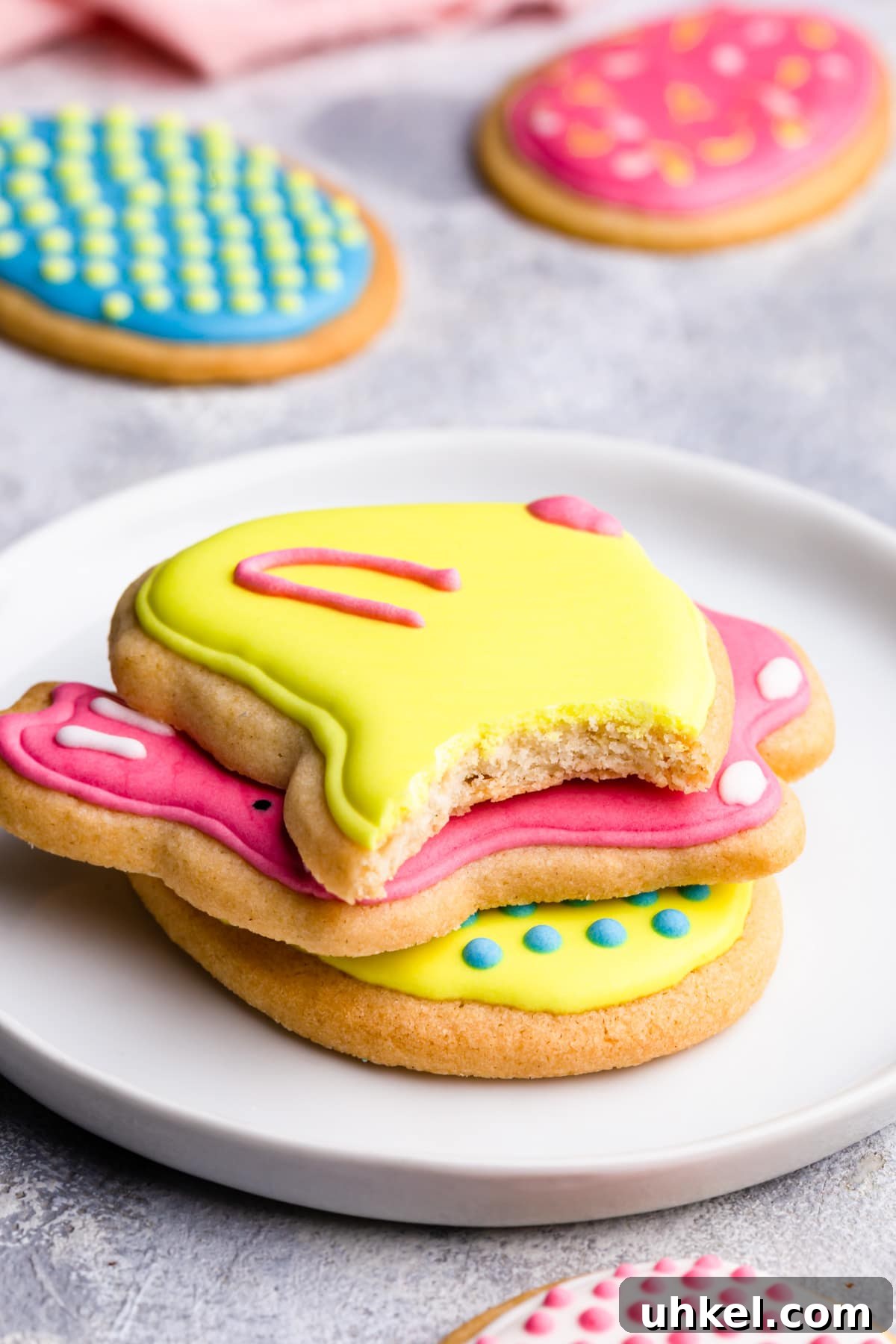 Easter Sugar Cookie Recipe with Simple Decorating Ideas 9 side close up at stack of sugar cookies with top one missing a bite