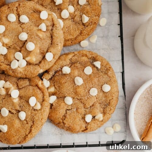 Pumpkin cookies with white chocolate chips on parchment paper.