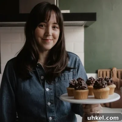Maple-Glazed Pumpkin Walnut Bread Recipe 13 Ella from Alpine Ella is holding a cake stand with cupcakes on it.