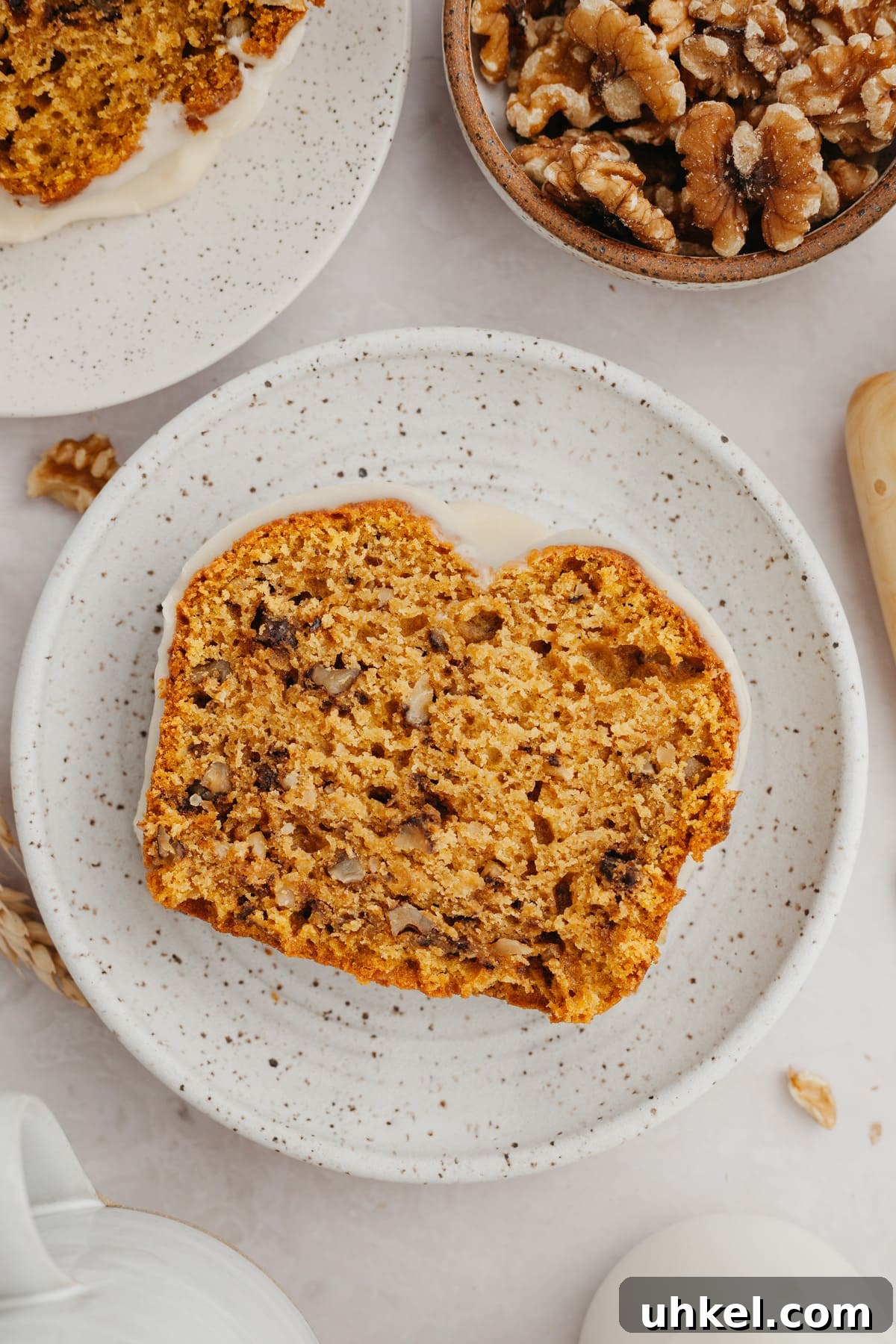 Maple-Glazed Pumpkin Walnut Bread Recipe 8 A slice of pumpkin bread on a small plate.