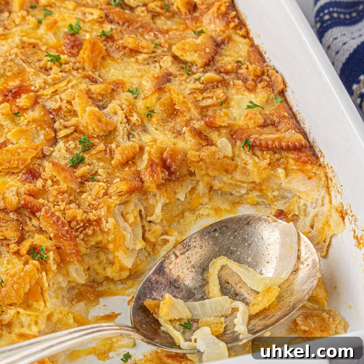 15 Perfect Side Dishes to Serve with Ham This Holiday 6 Closeup of Southern sweet onion casserole with a spoon in it.