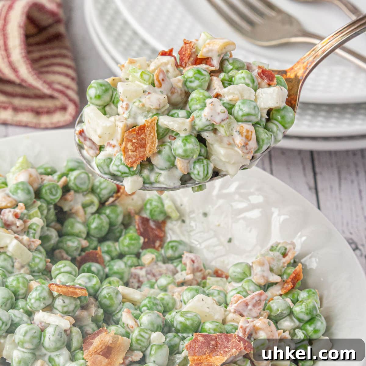 15 Perfect Side Dishes to Serve with Ham This Holiday 9 A spoonful of pea salad with cashews being served.