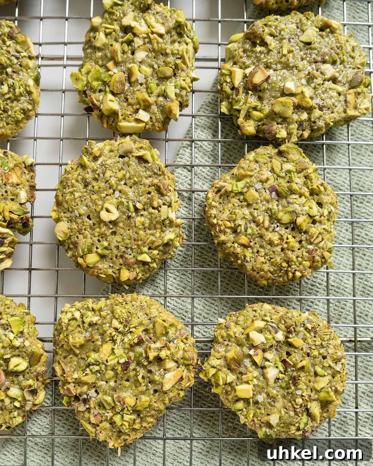 Authentic Italian Pistachio Cookies Recipe for Crispy, Nutty Treats 2 Italian pistachio cookies on a cooling rack.