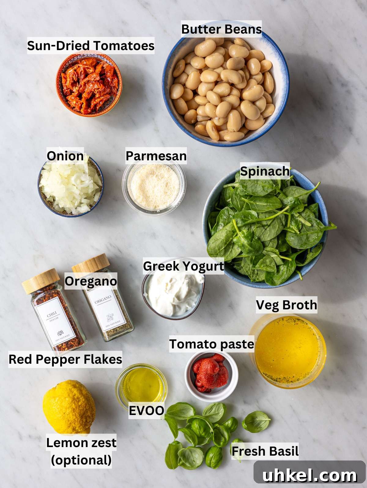 Greek Yogurt Marry Me Butter Beans Recipe 3 Fresh ingredients and canned butter beans arranged on a bright marble surface in natural light.