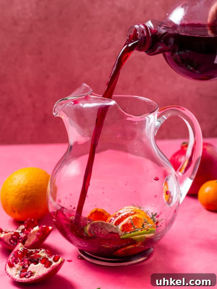 pouring pomegranate juice in a glass pitcher