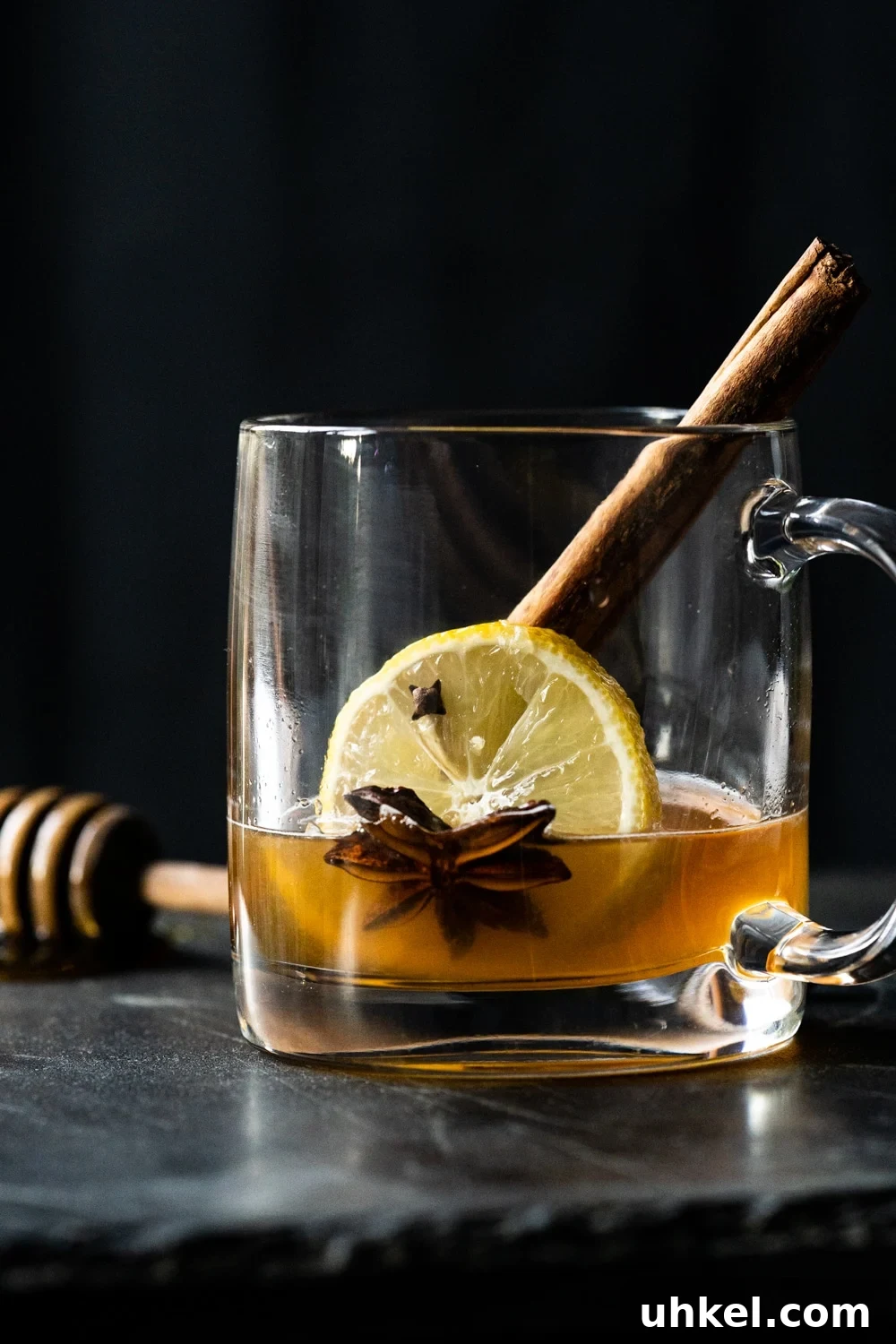 Preparing a keto hot toddy with cinnamon, lemon, star anise, cloves