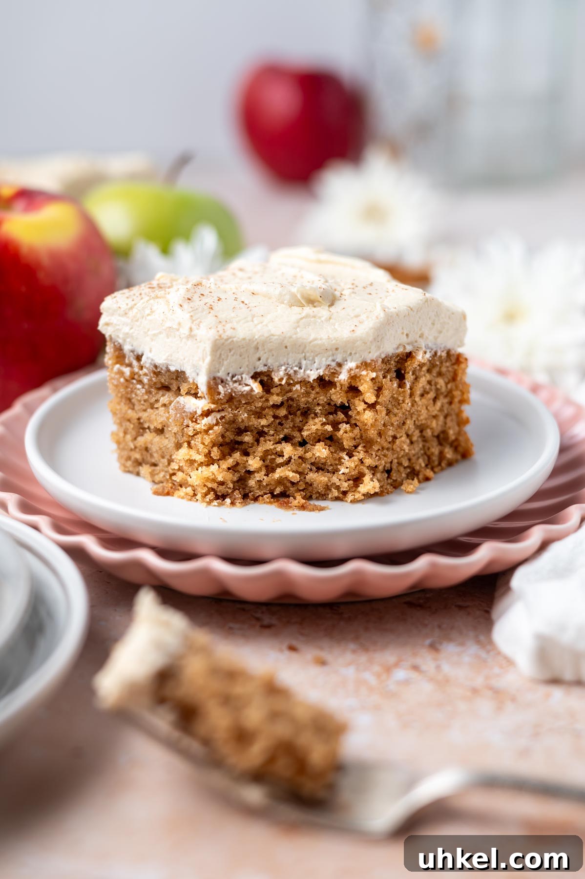 Apple Cider Snack Cake with Tender Apples 2 slice of apple snack cake with brown sugar frosting on a plate
