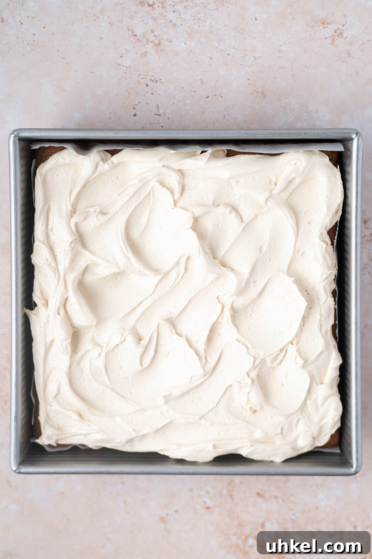 Apple Cider Snack Cake with Tender Apples 10 brown sugar frosting on cake in a baking tin