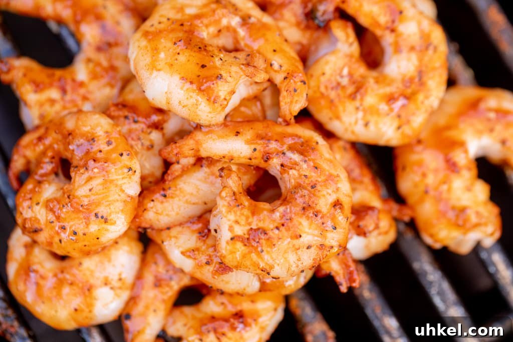 Grilled BBQ Shrimp with Creamy Southern Grits 3 Seasoned and grilled shrimp piled on the grill grates of a BBQ grill.