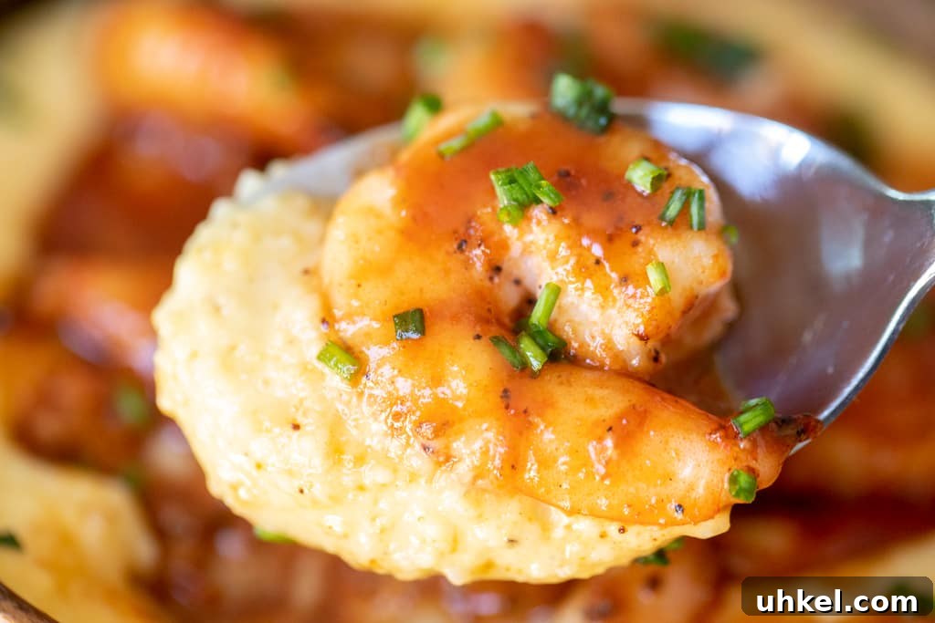Grilled BBQ Shrimp with Creamy Southern Grits 5 Closeup of grilled shrimp and grits on a metal spoon.