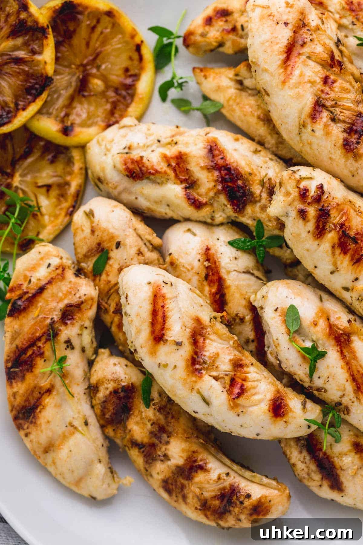 Crispy Grilled Chicken Tenders with Tangy BBQ Glaze 2 Grilled chicken tenders on a white serving plate