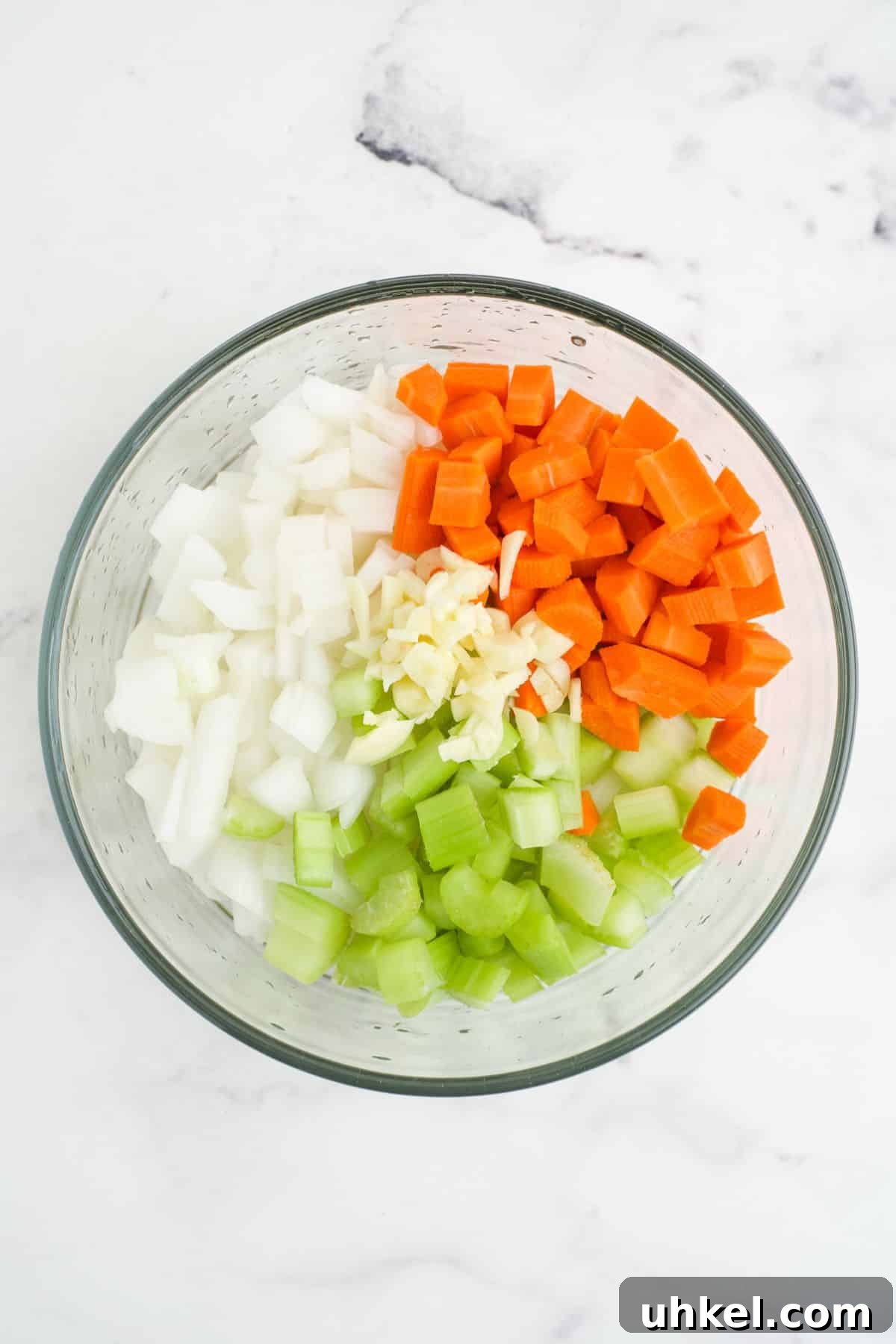 Hearty Slow Cooker 15-Bean Soup Recipe for Meal Prep 5 Chopped aromatic vegetables in a glass bowl.