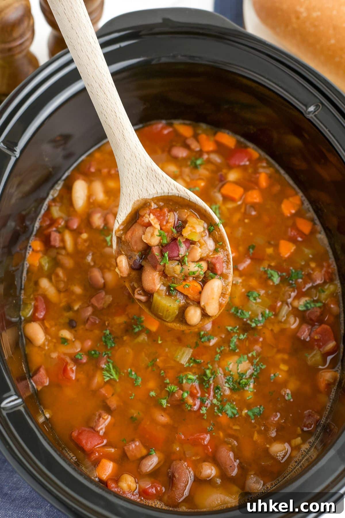 Hearty Slow Cooker 15-Bean Soup Recipe for Meal Prep 8 15 bean soup in the crock pot with a spoon lifting out a serving.