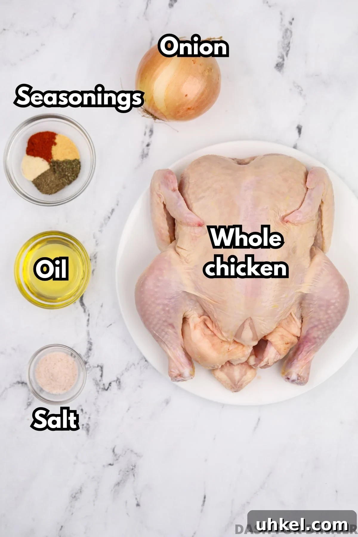 A whole chicken, with small bowls of oil, seasoning, and salt around the perimeter.