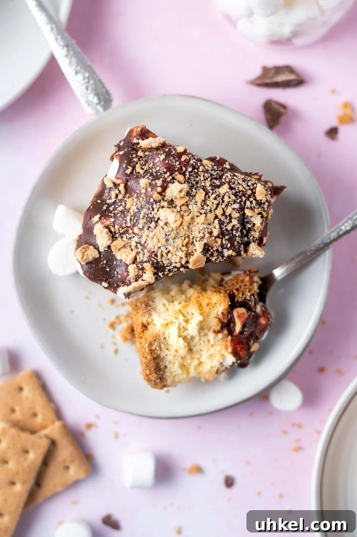 slice of s'mores cake on a plate with a bite on a fork
