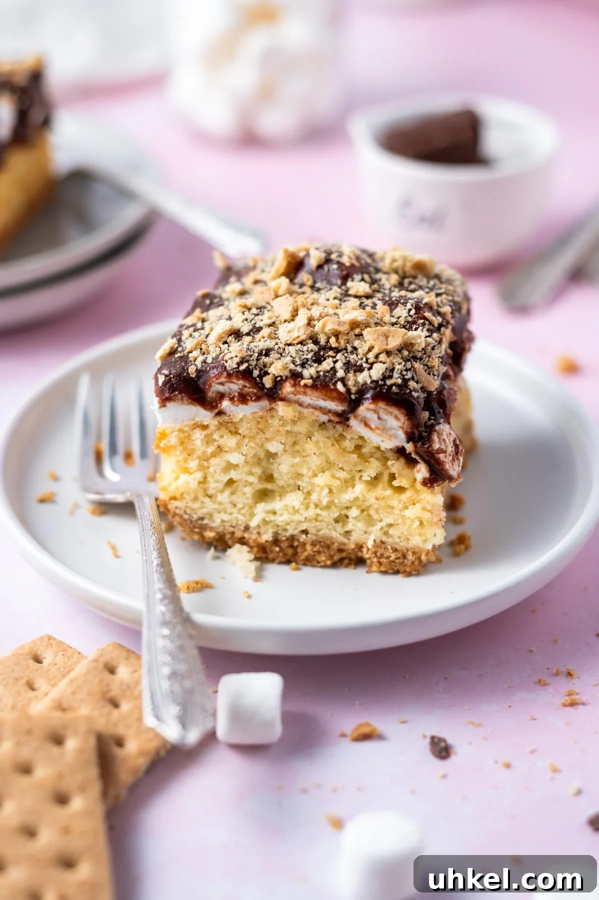 slice of s'mores cake on a plate with a fork