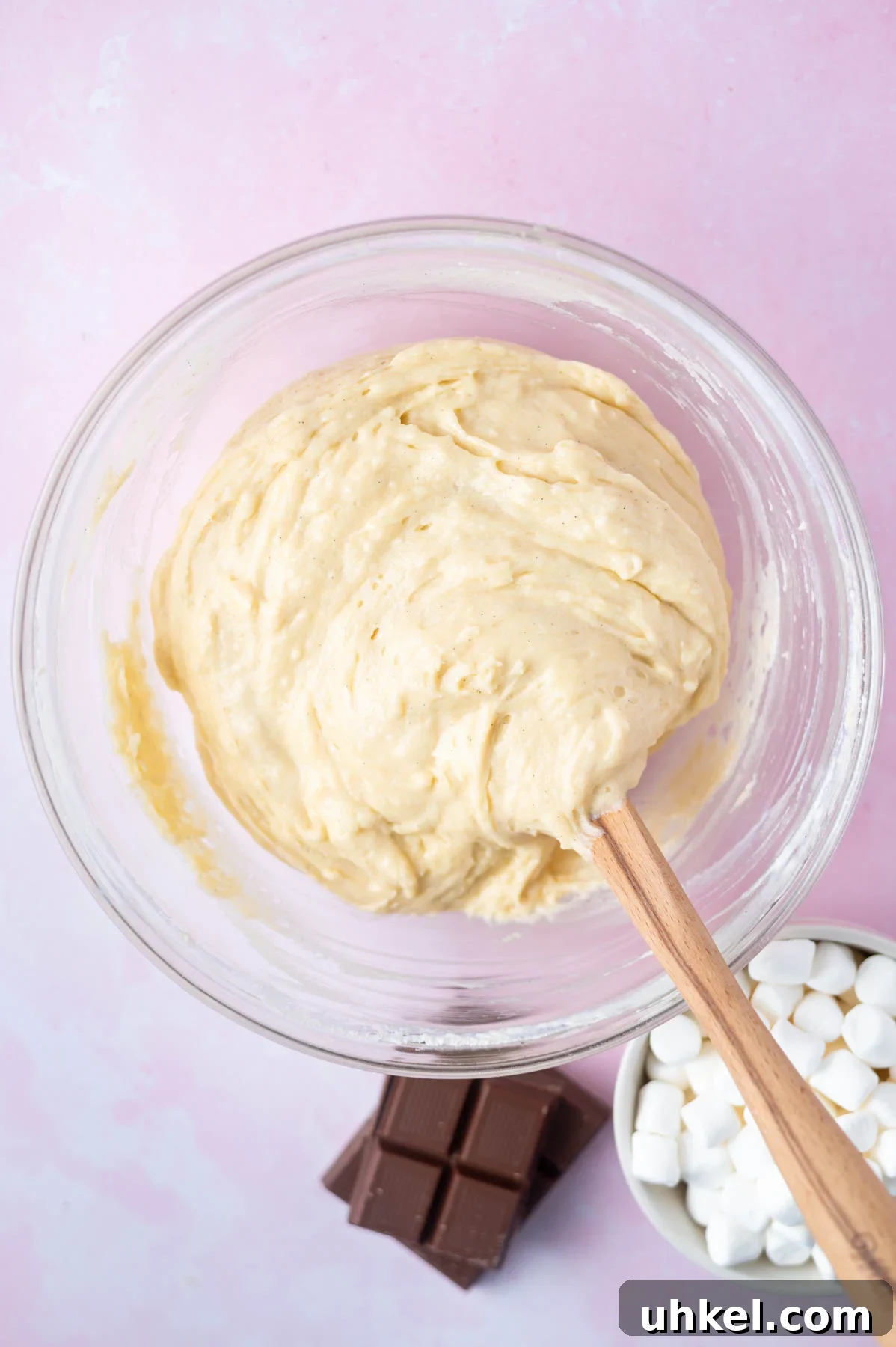 vanilla cake batter in a glass bowl with a spatula