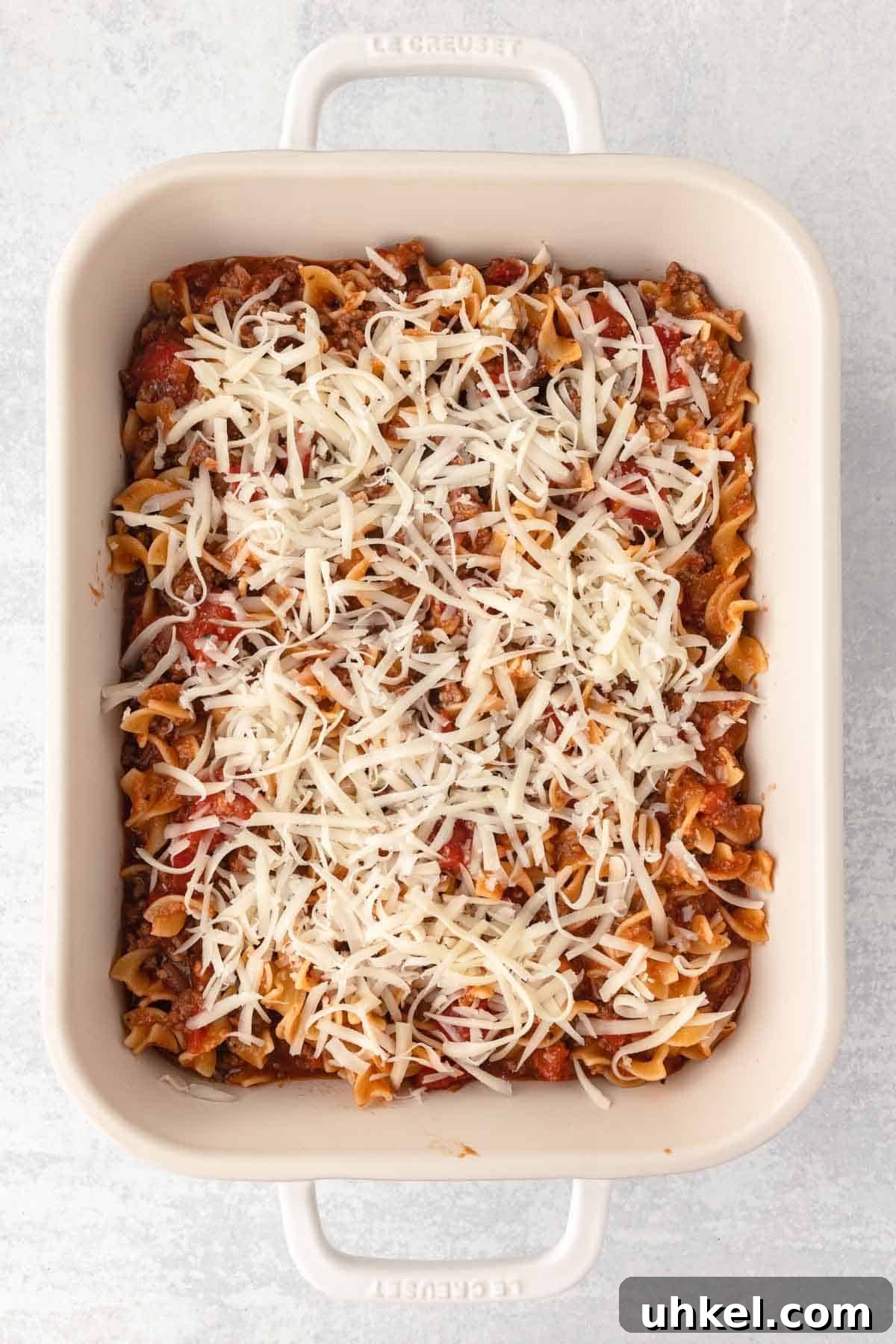 Italian Beef and Egg Noodle Casserole with Tomatoes and Cheese 7 Beef and noodle mixture is spread into a prepared casserole dish and topped with an even layer of mozzarella shreds.