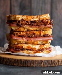 Chili Cheese Dog Grilled Cheese 3 sandwiches stacked on each other with chili cheese dogs spilling out