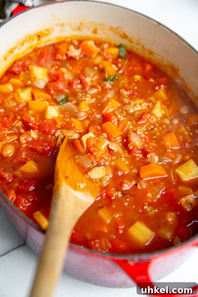 Hearty Vegan Quinoa Chili Recipe: Protein-Packed & Flavorful 11 Close up of the chili in a pot with a wooden spoon.