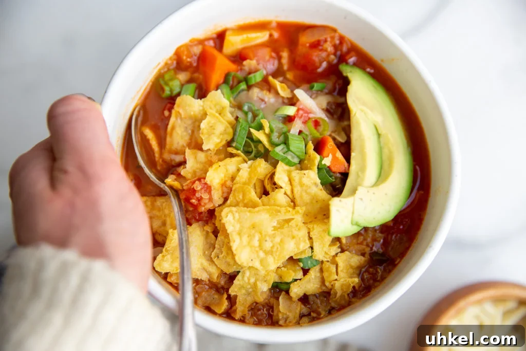 Hearty Vegan Quinoa Chili Recipe: Protein-Packed & Flavorful 3 A hand holding a bowl of quinoa chili.