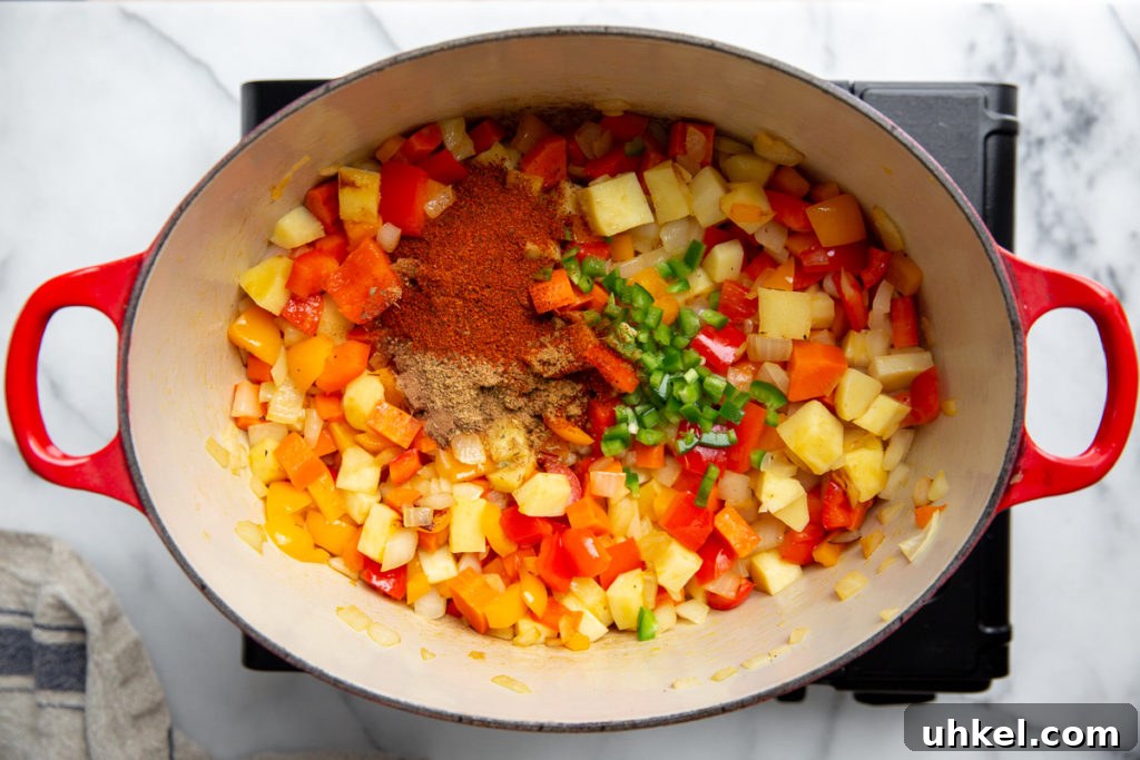Hearty Vegan Quinoa Chili Recipe: Protein-Packed & Flavorful 7 Process shot showing the cooked vegetables, spices, garlic and jalapeno in a pot for the chili recipe.