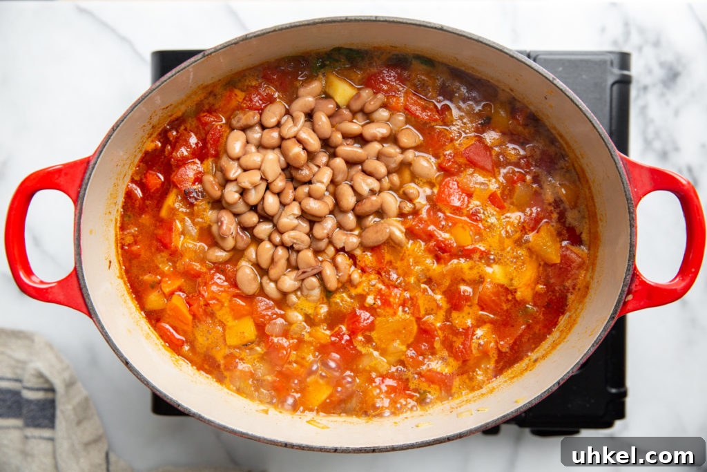 Hearty Vegan Quinoa Chili Recipe: Protein-Packed & Flavorful 9 Process shot showing the beans being added to the vegetable chili.